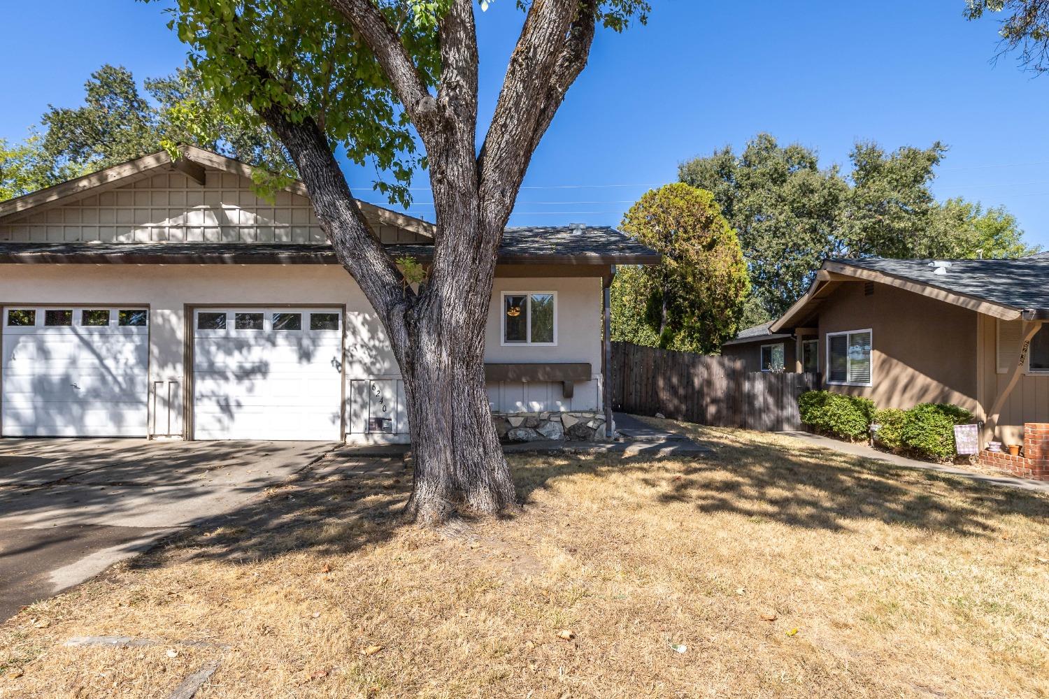 a view of a house with a tree in the background