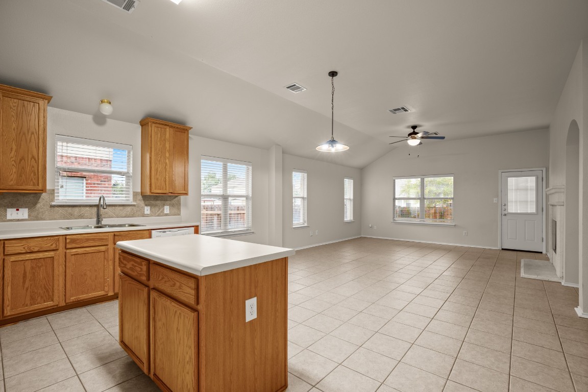 a large kitchen with kitchen island granite countertop a sink counter space cabinets and a window