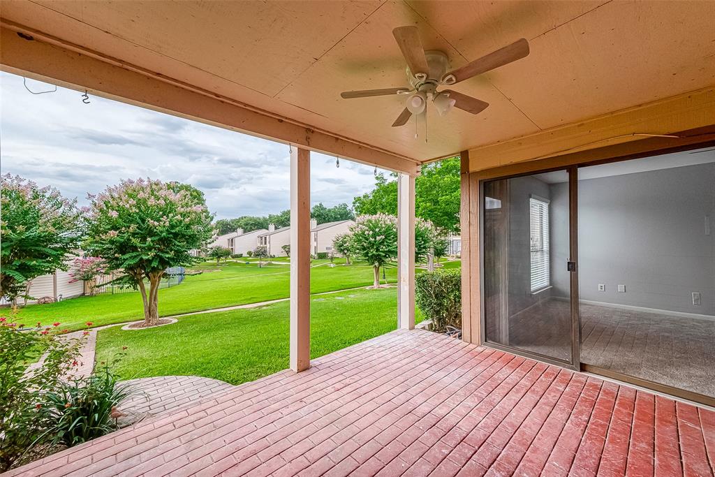 a view of a porch with wooden floor and a yard