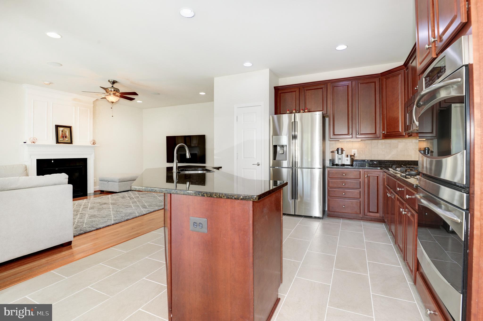 a kitchen with stainless steel appliances granite countertop a refrigerator a stove top oven a sink and dishwasher