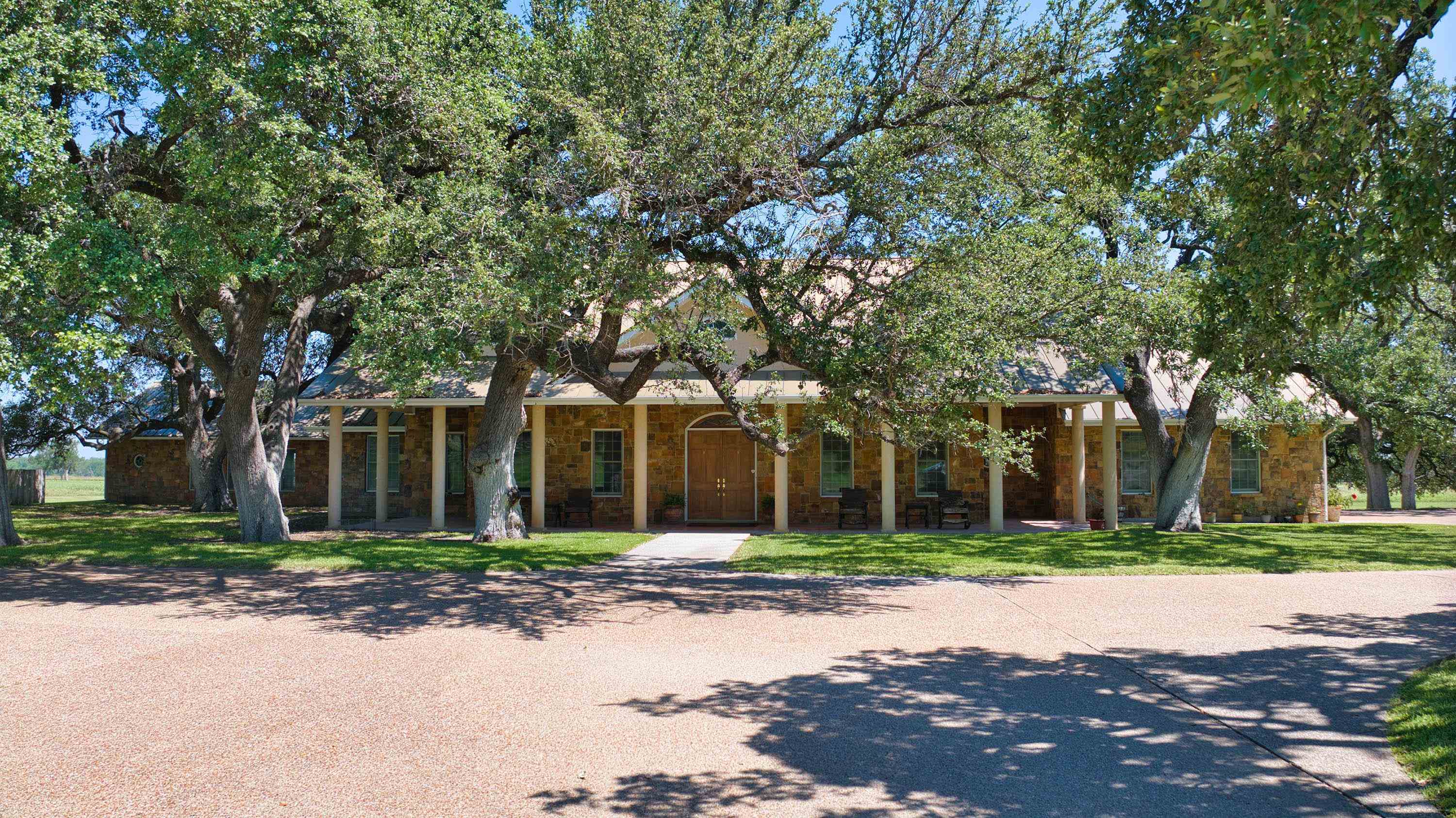 front view of a brick house with a large trees