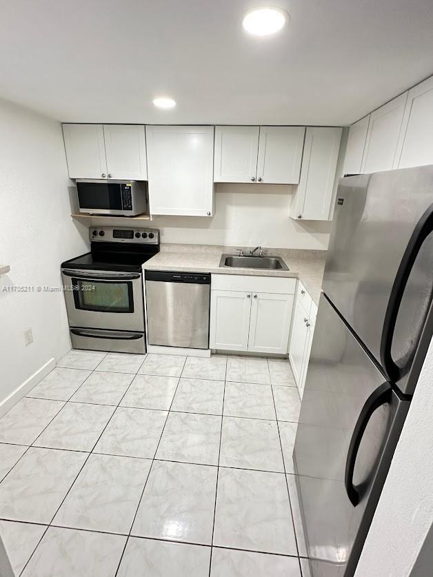 a kitchen with granite countertop a stove a sink and a refrigerator