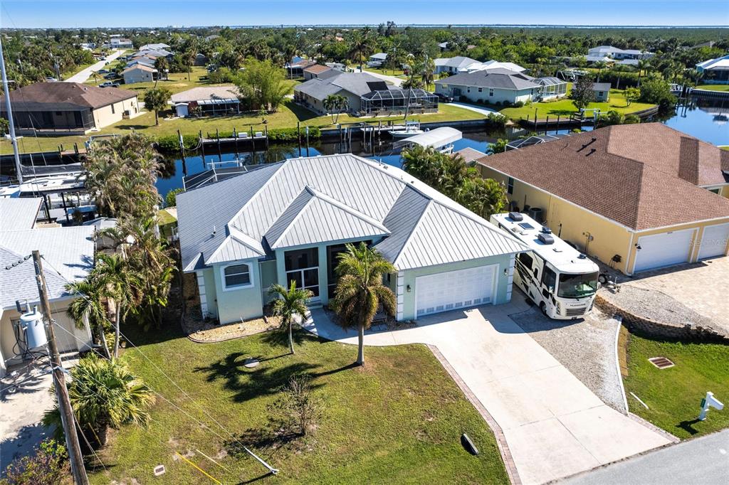 an aerial view of a house with swimming pool and large trees