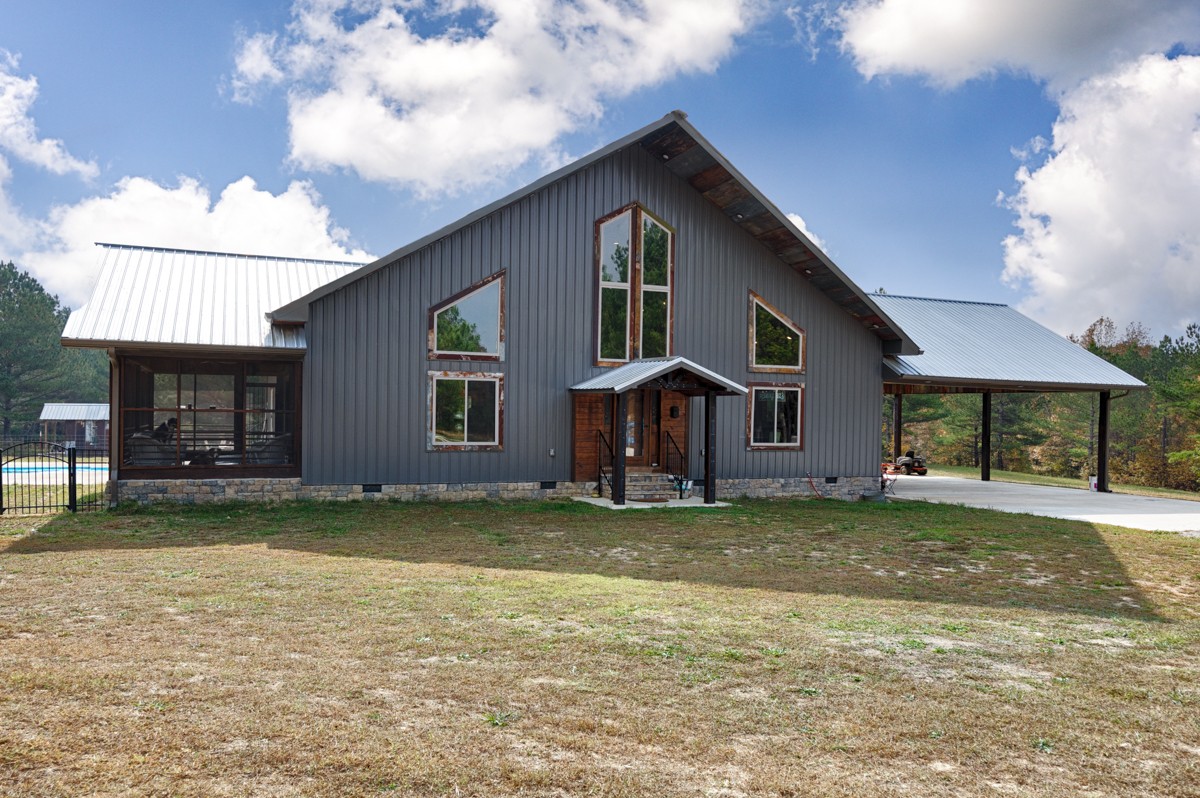 a view of a house with a patio and a yard