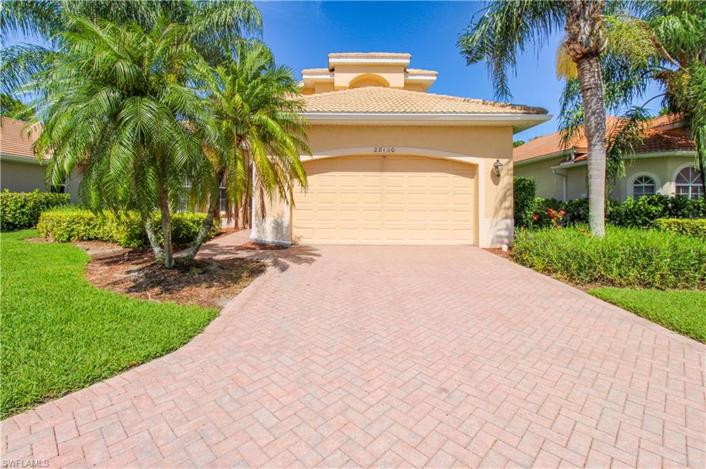 a view of a house with a yard and palm trees