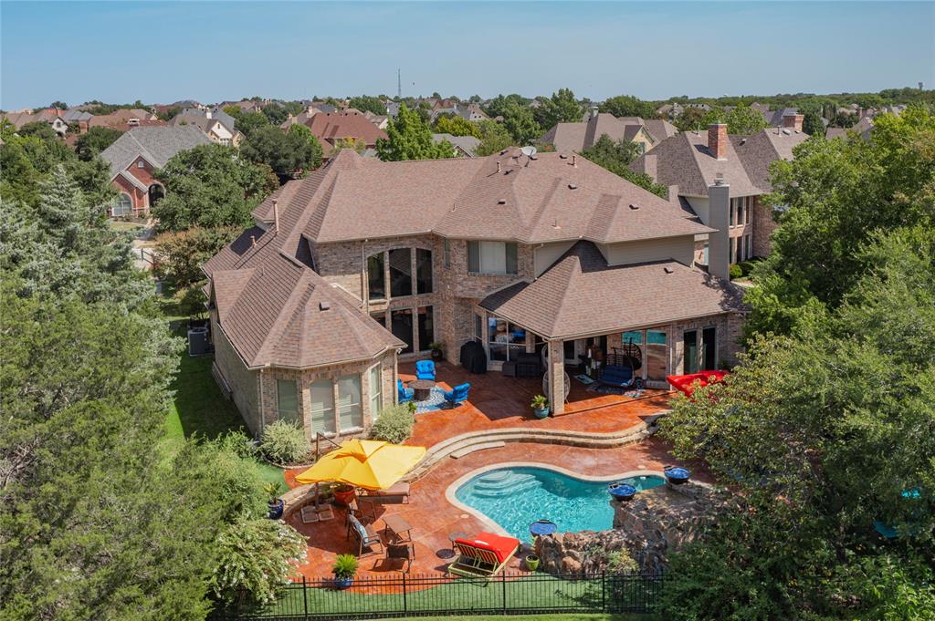 an aerial view of a house with swimming pool and outdoor seating