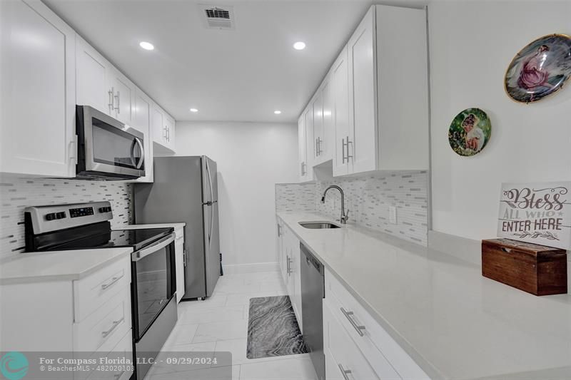 a kitchen with stainless steel appliances granite countertop a sink and a stove top oven