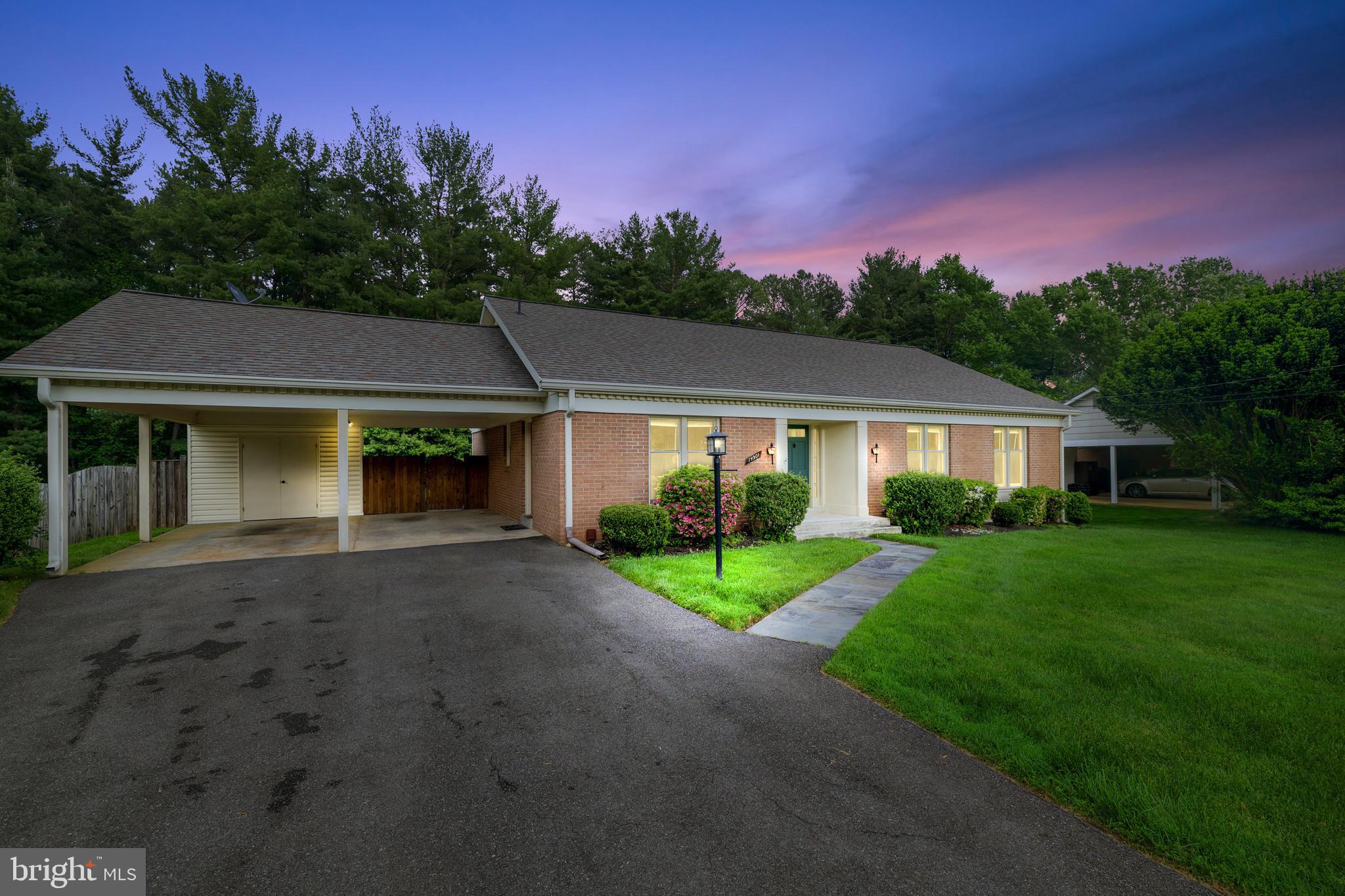 a front view of a house with a yard and trees