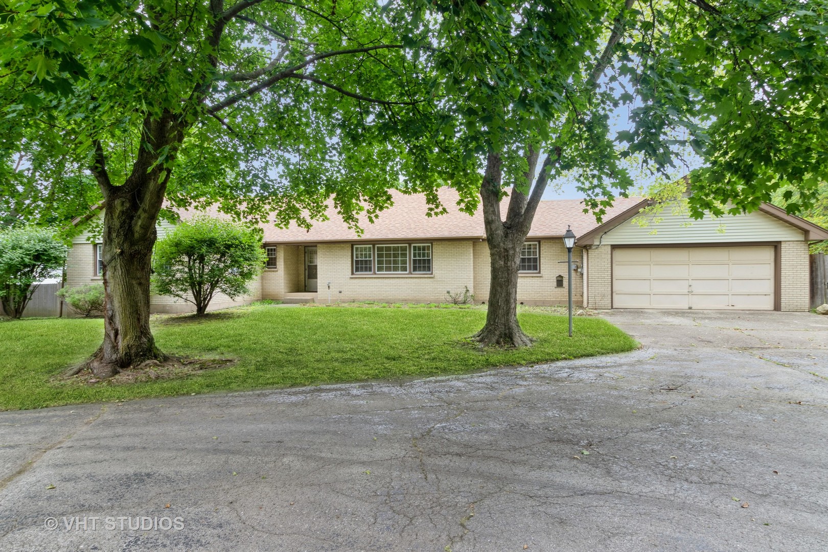 a front view of a house with a yard and an trees