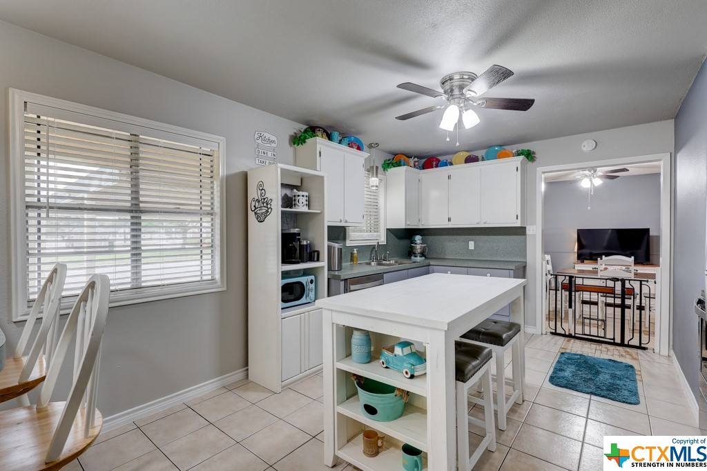 a kitchen with stainless steel appliances a stove a refrigerator and a dining table