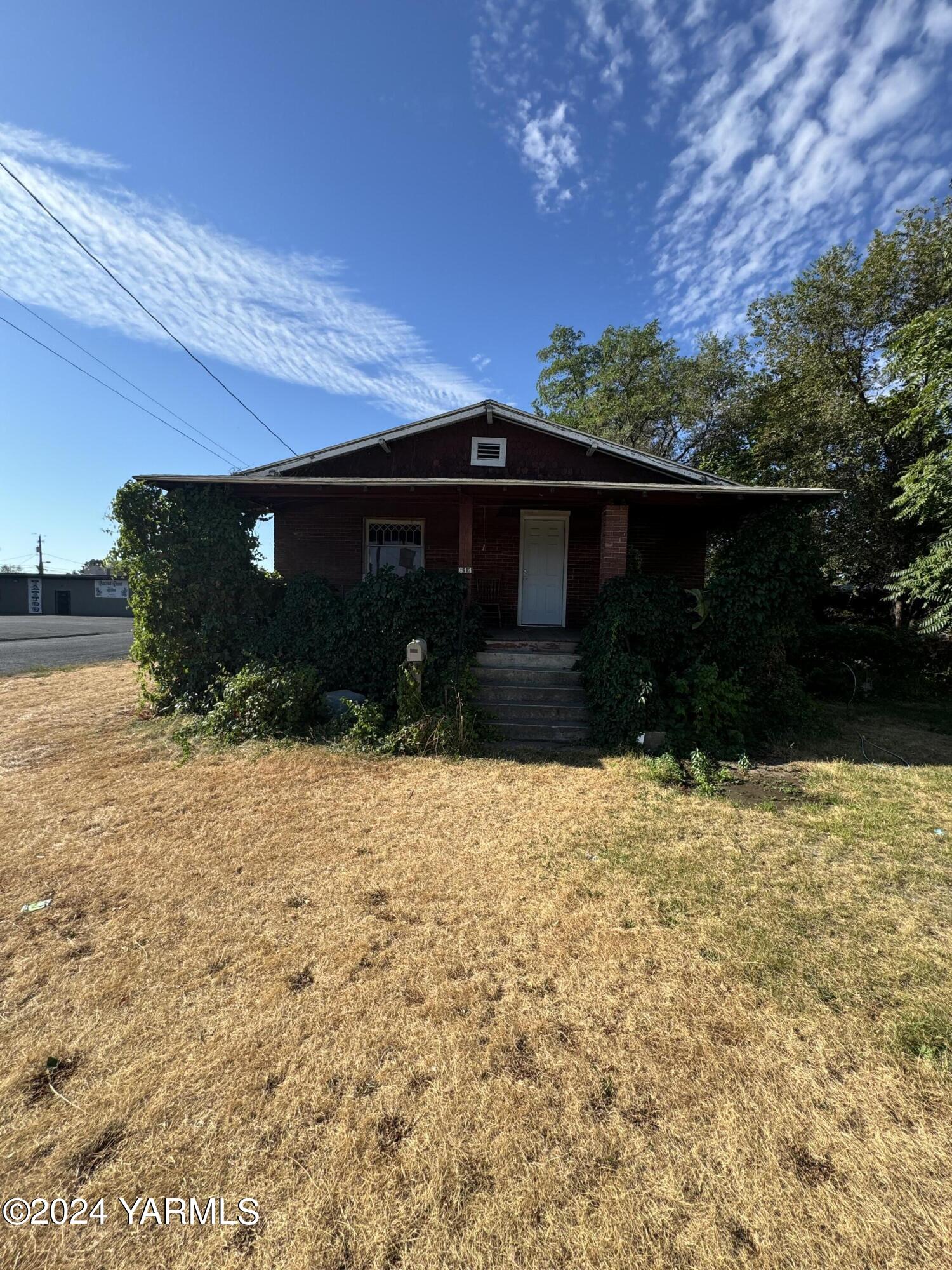 a front view of house with yard and trees