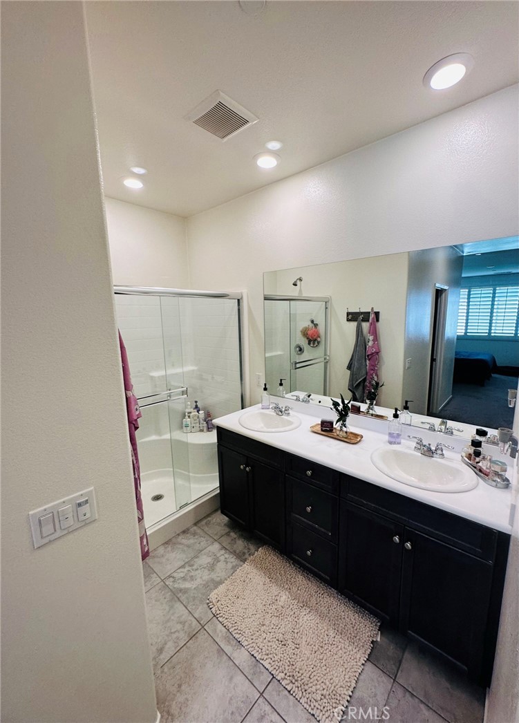 a spacious bathroom with a double vanity sink a mirror and a bathtub