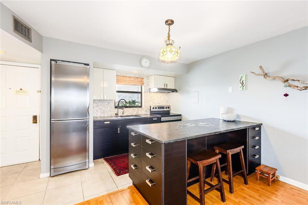 a kitchen with a table chairs refrigerator and microwave