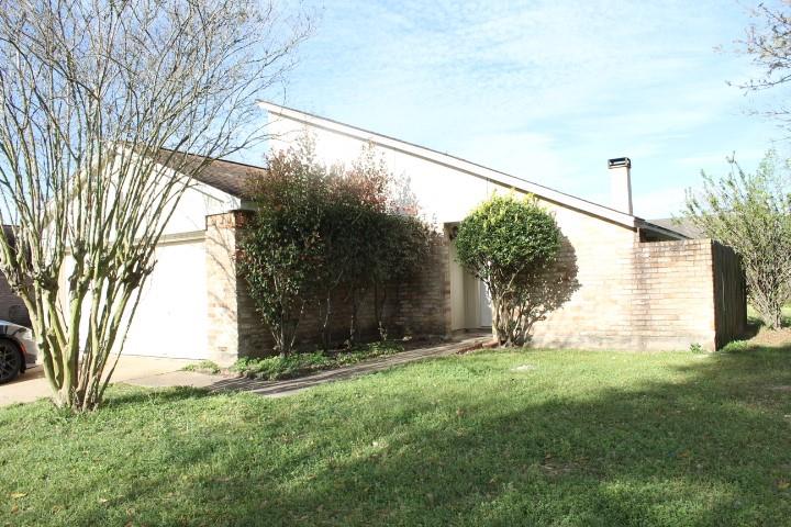 a view of a back yard with an tree and wooden fence