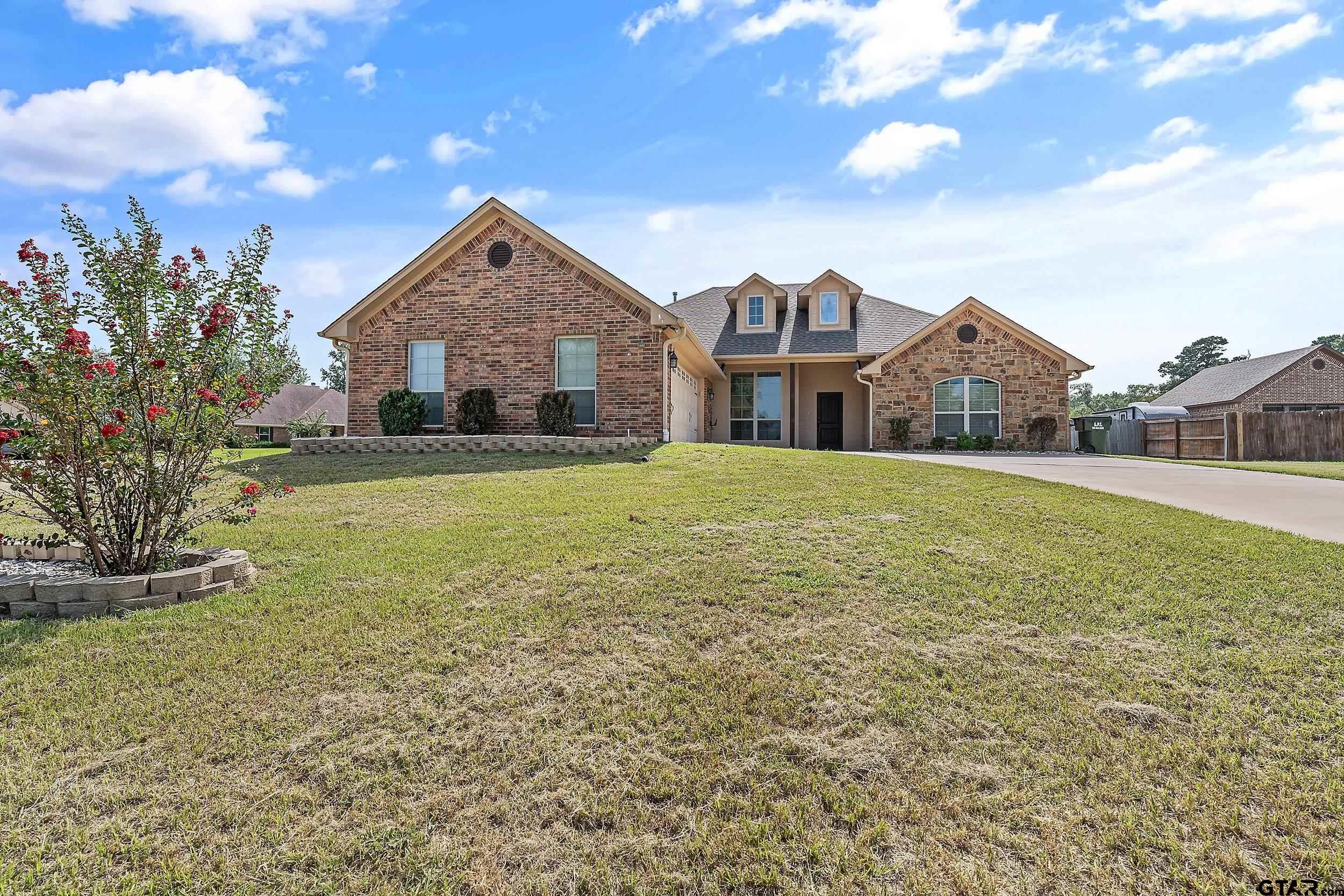 a front view of a house with yard and green space