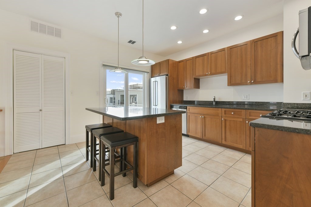 a kitchen with stainless steel appliances granite countertop a stove a sink and a refrigerator