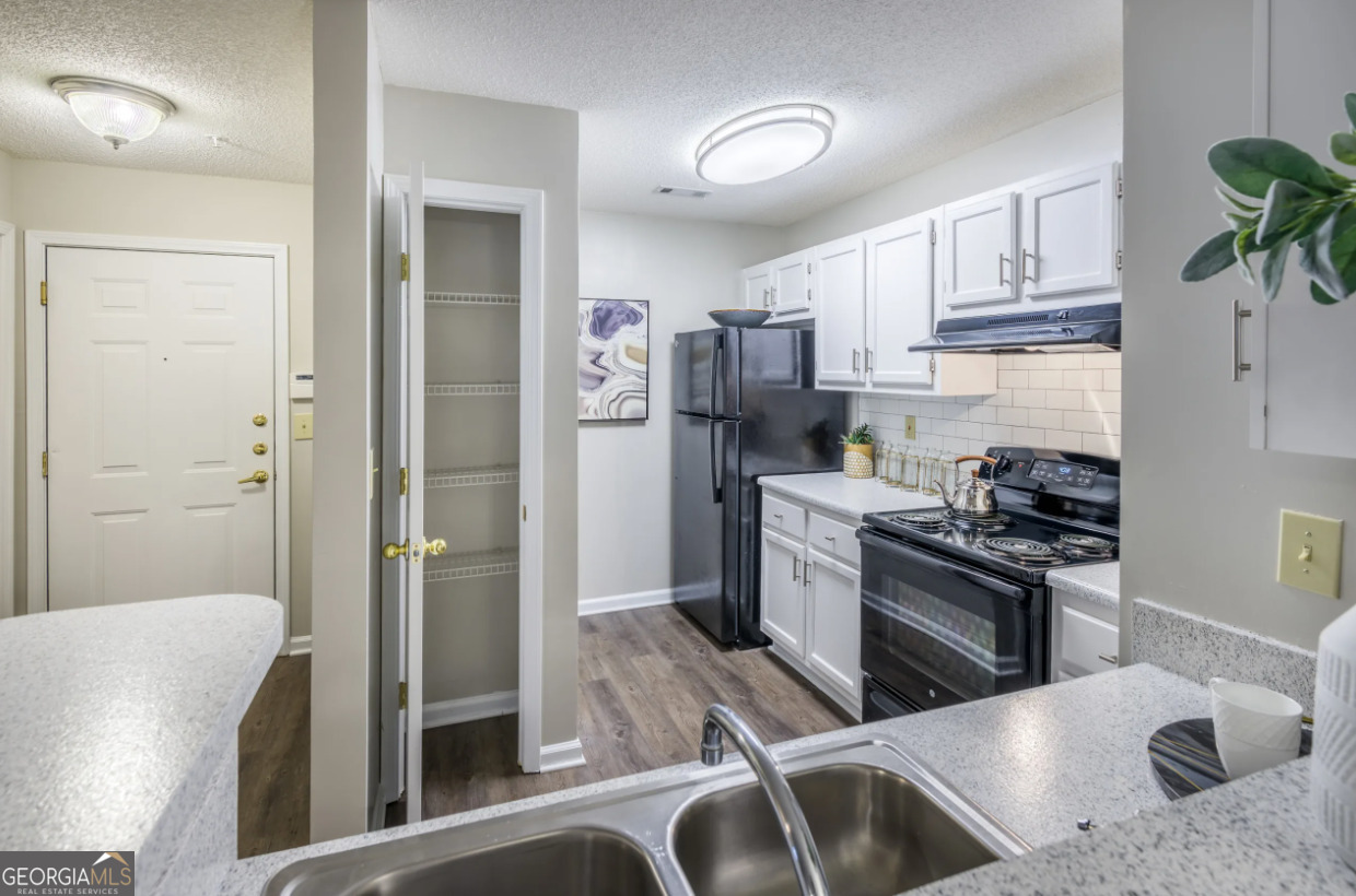 a kitchen with stainless steel appliances granite countertop a refrigerator sink and stove