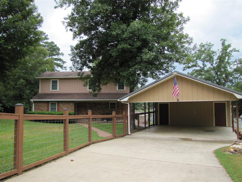 a view of a house with a backyard and a large tree