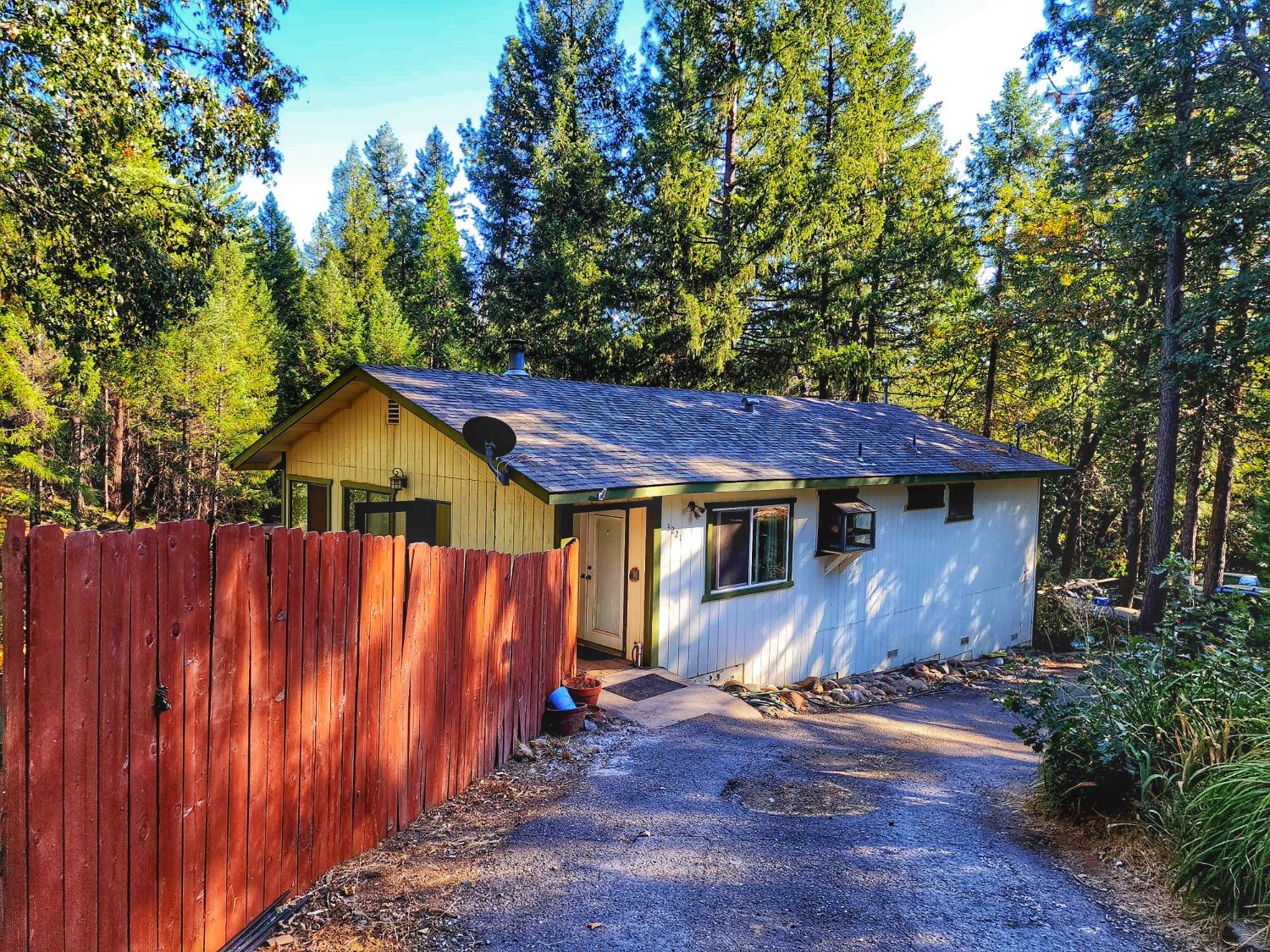 a view of a small house with wooden fence