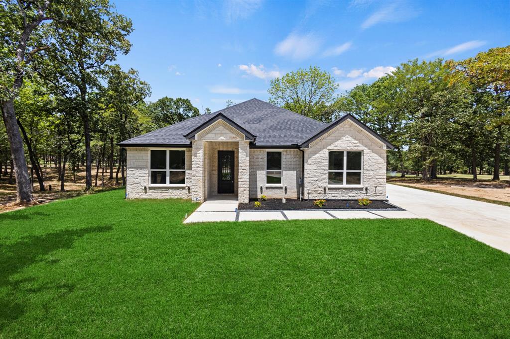 a white house with a big yard and potted plants in front of a house