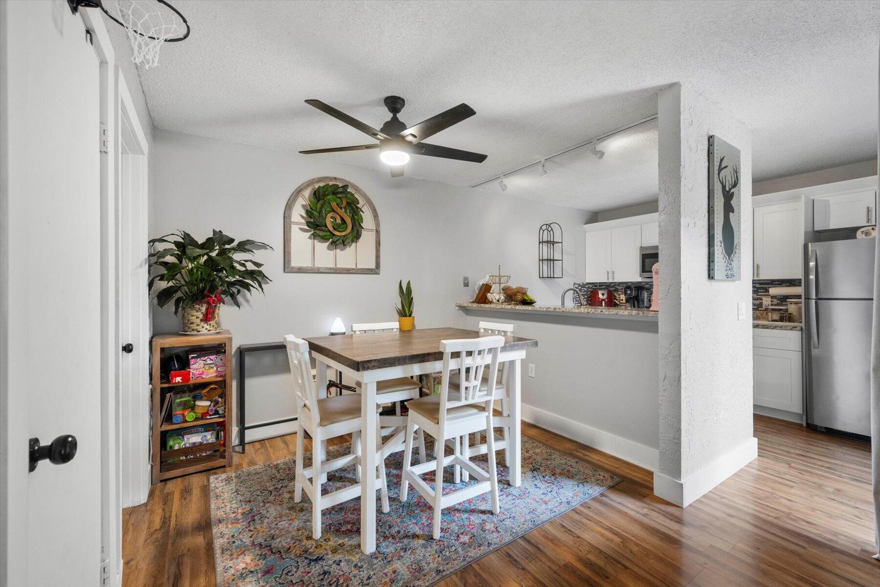 a view of a dining room with furniture and a chandelier fan