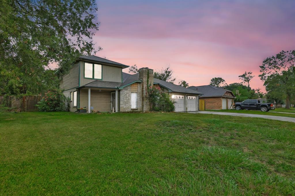 a front view of a house with a yard and trees