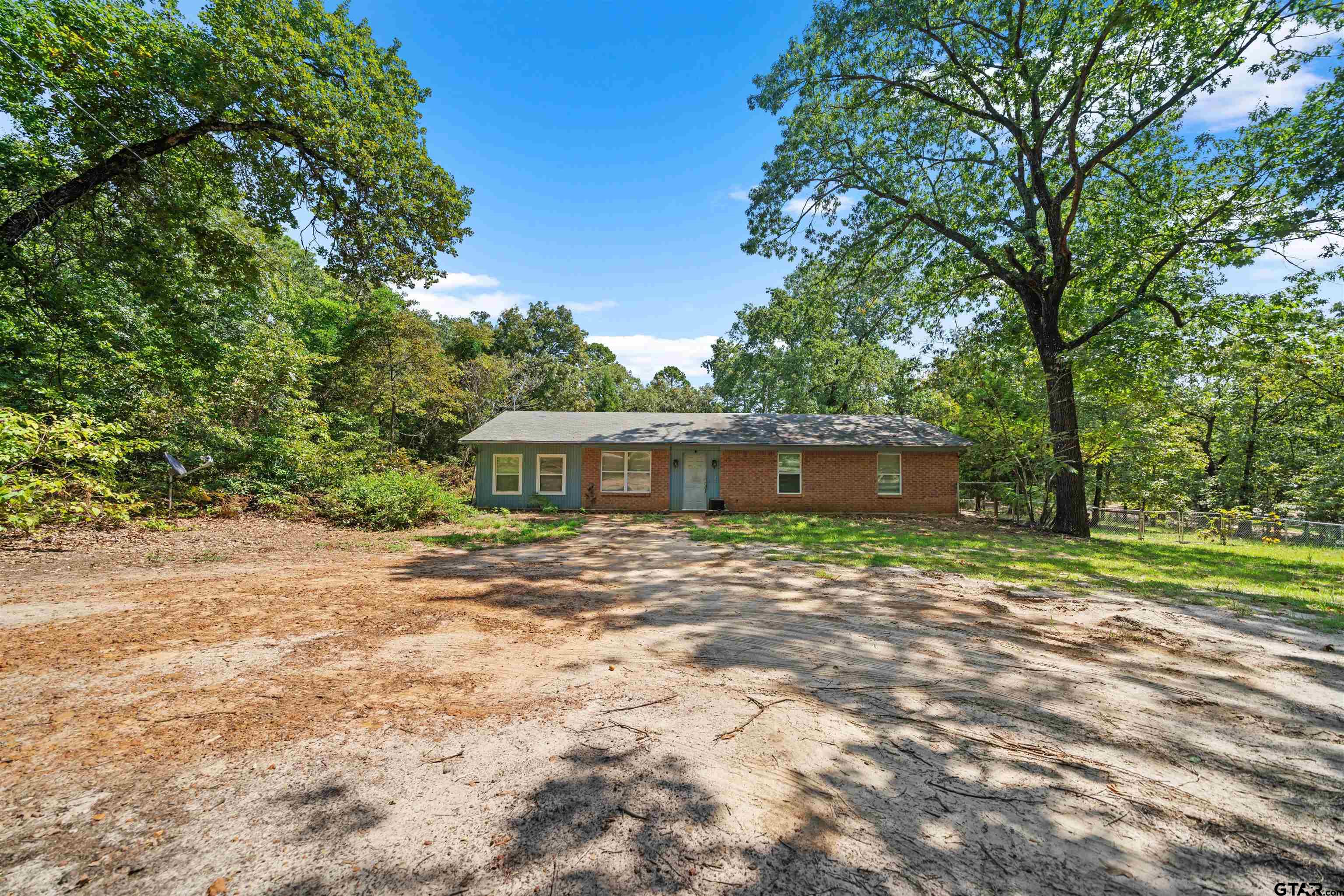 a front view of a house with a yard and trees