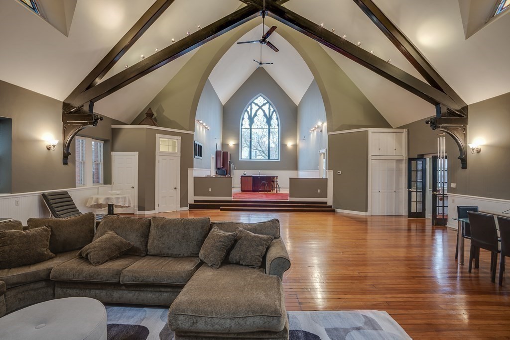 a living room with furniture and a wooden floor