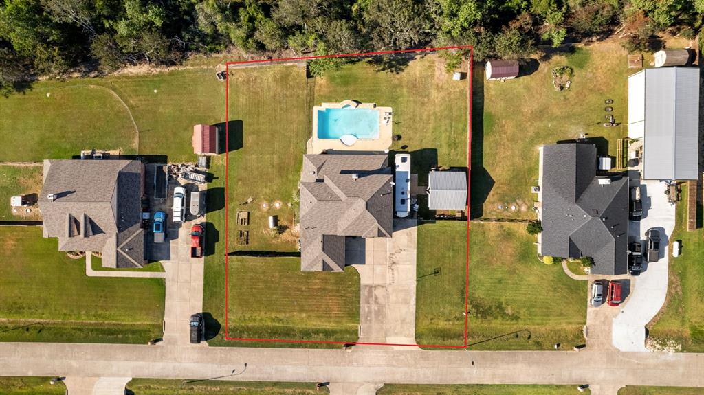 an aerial view of residential houses with outdoor space and parking