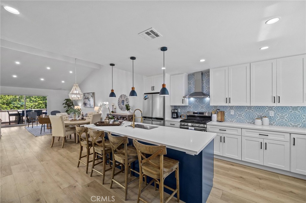 a kitchen with a dining table chairs sink and wooden floor