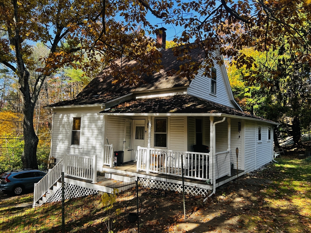 a view of a house with a small yard and wooden fence