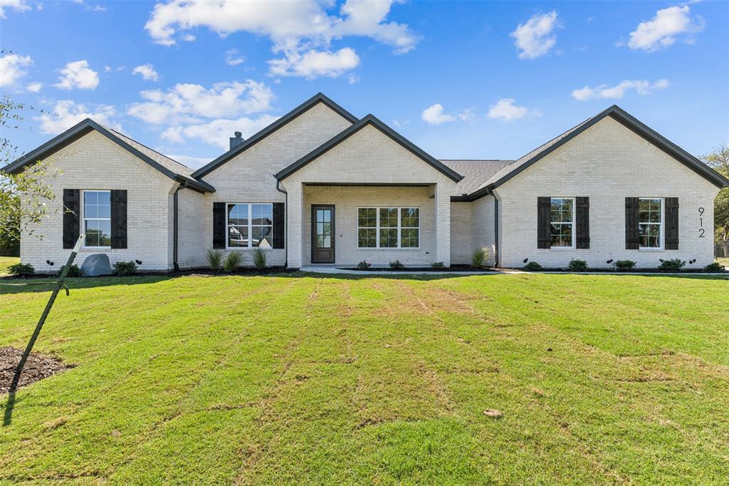 a front view of house with yard outdoor seating and flat screen tv