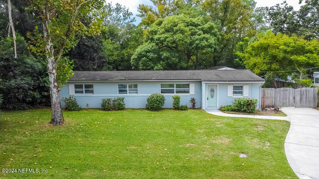 a front view of house with a garden and trees