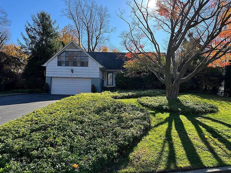 View of front of house featuring a garage and a front lawn