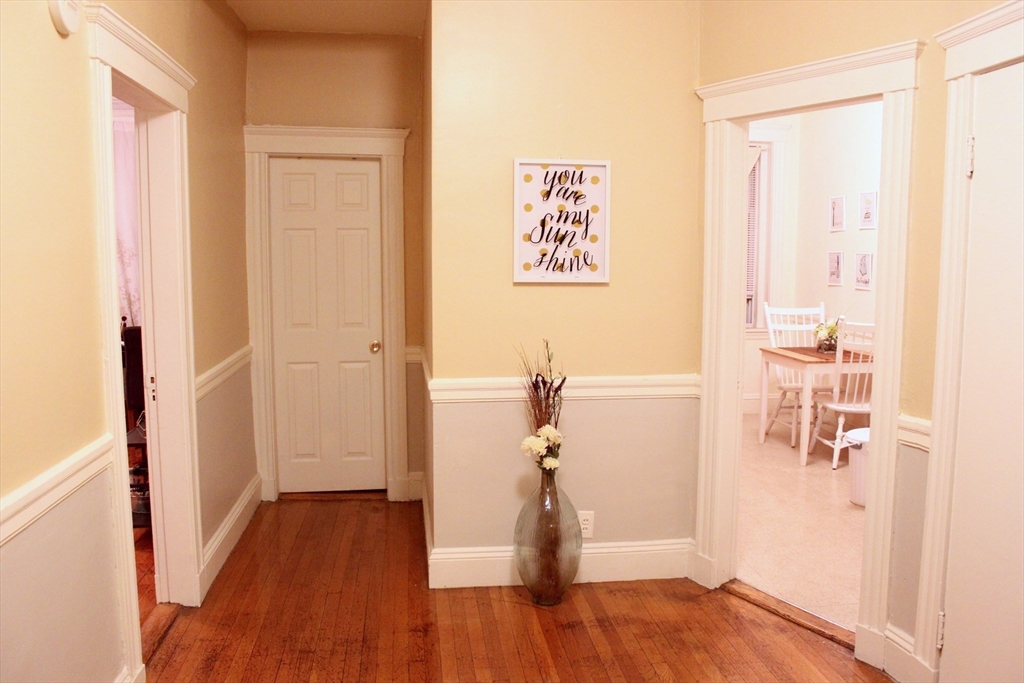 a view of a hallway with wooden floor and closet