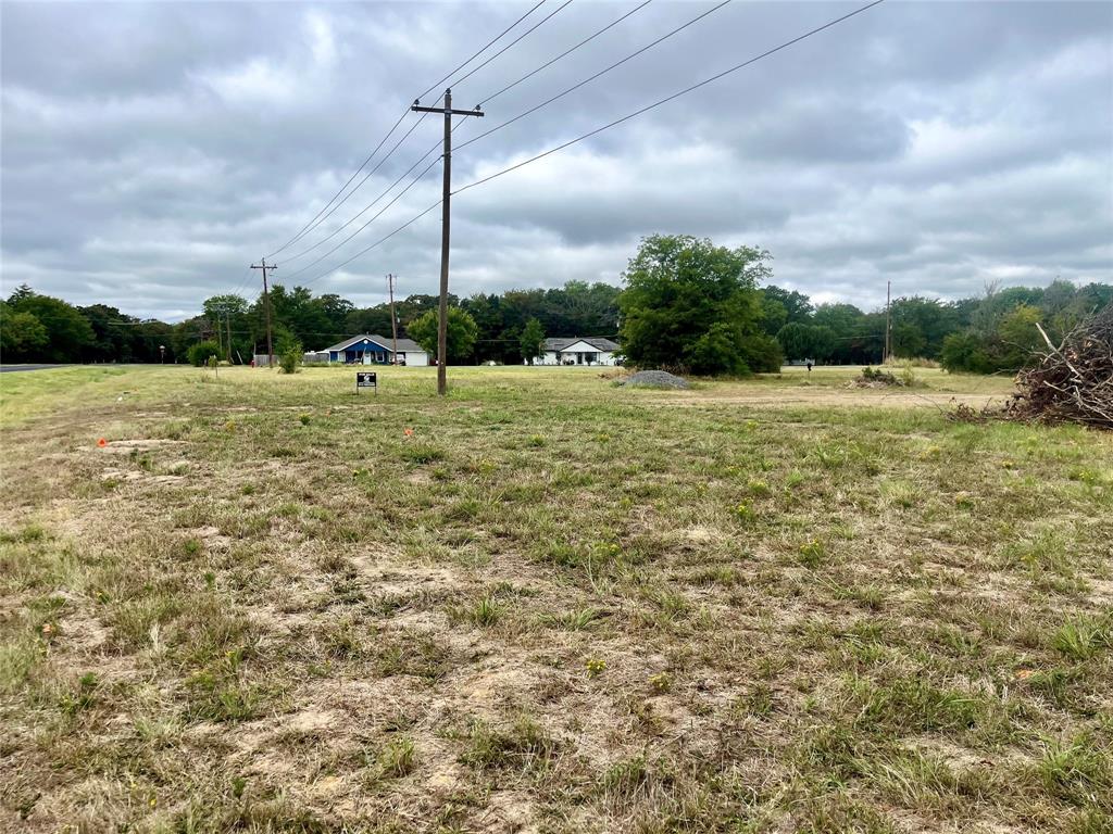 a view of a field with an buildings in the background