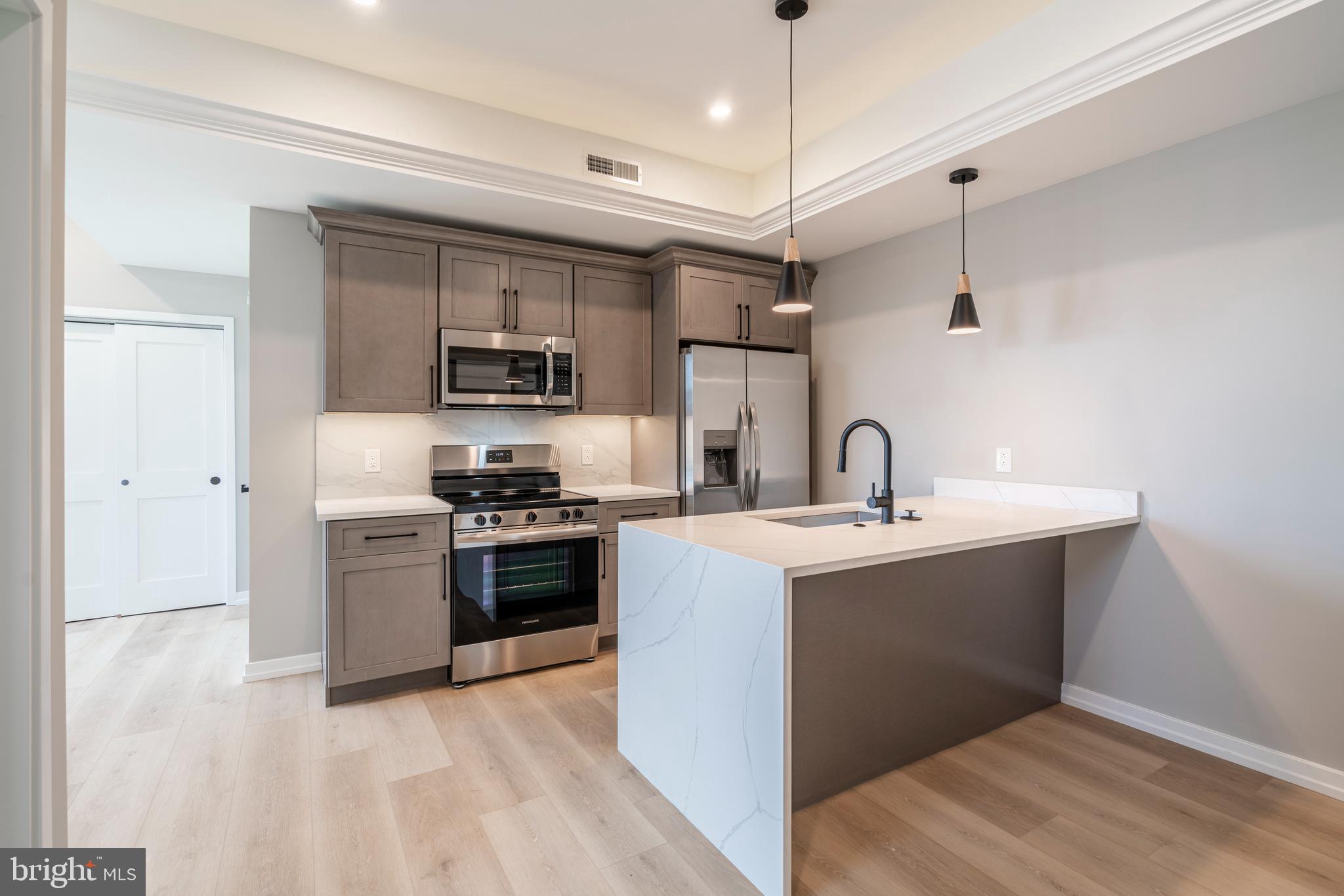 a kitchen with stainless steel appliances granite countertop a sink and a stove