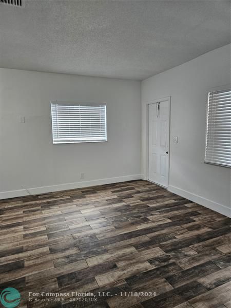 a view of a room with an empty space and wooden floor