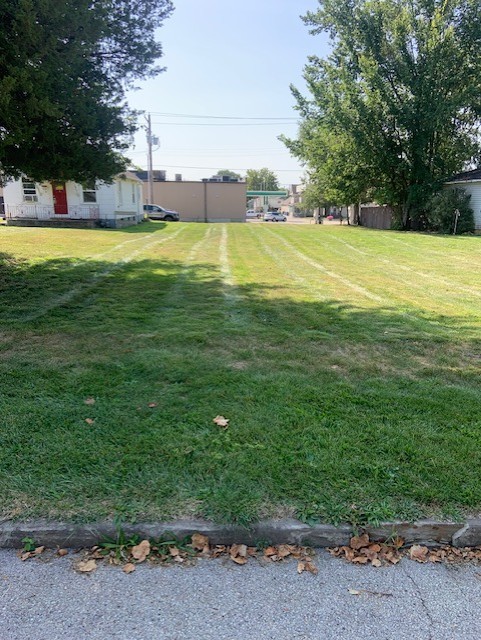 a view of a big yard with a small yard and large trees