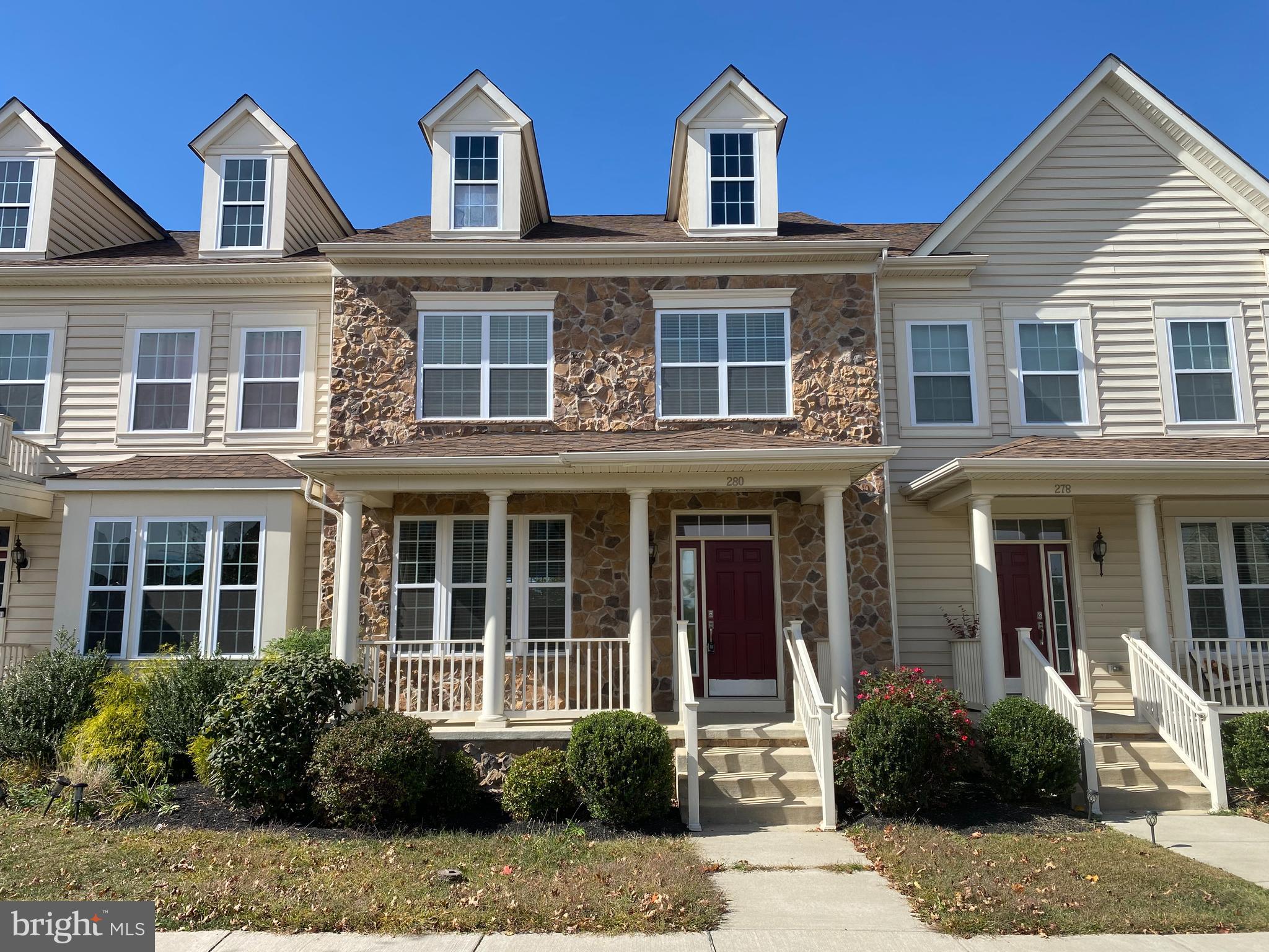 front view of a brick house with a yard