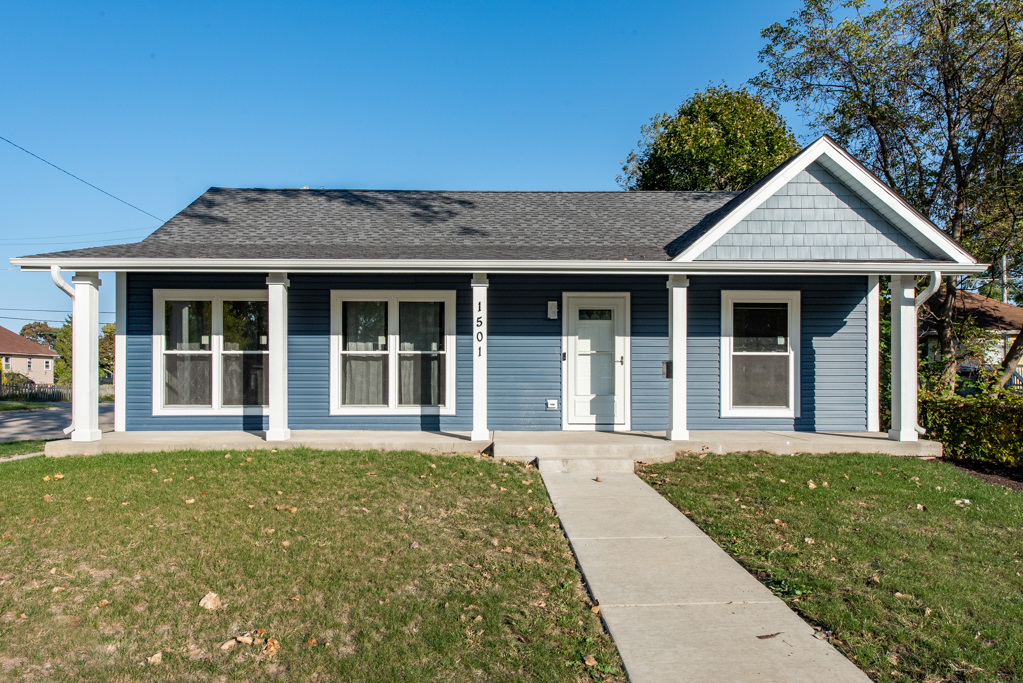 front view of a brick house with a yard