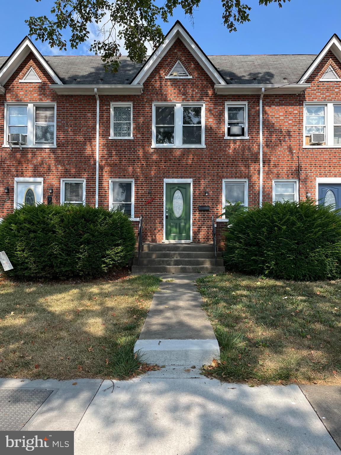 a front view of a house with yard and green space