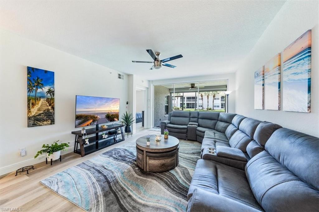 a living room with furniture a flat screen tv and a window