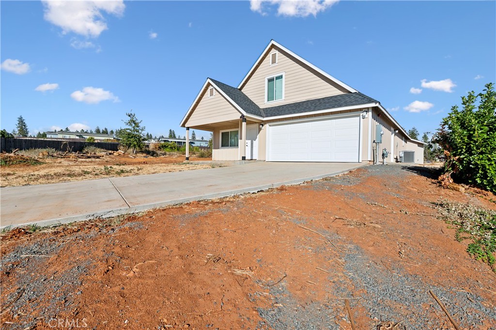 a view of a house with a yard and road