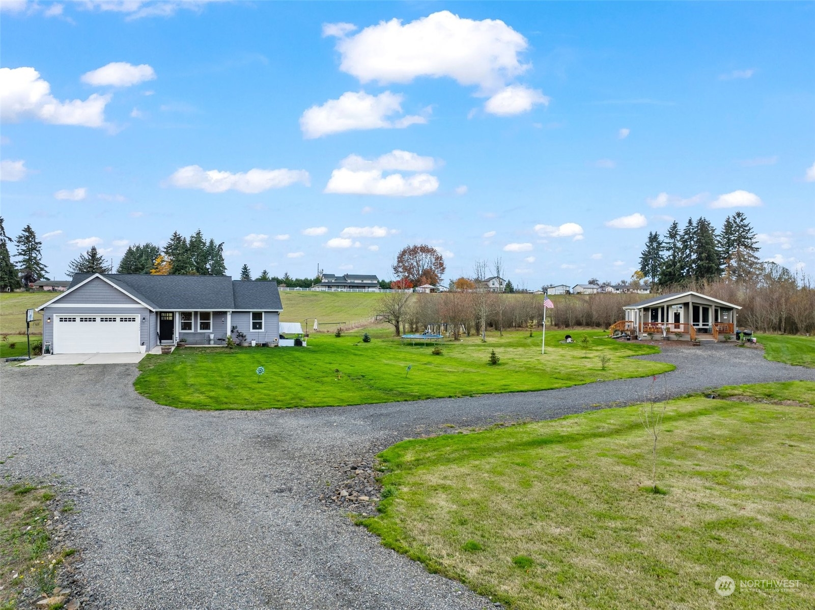 a view of a big house with a big yard and large trees