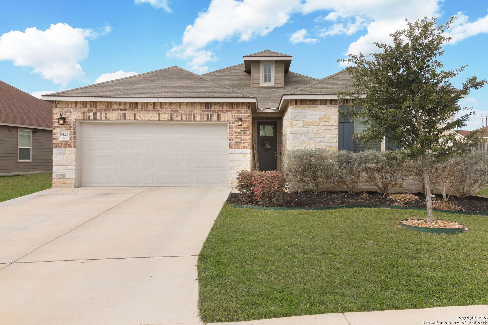 a front view of a house with a yard and garage