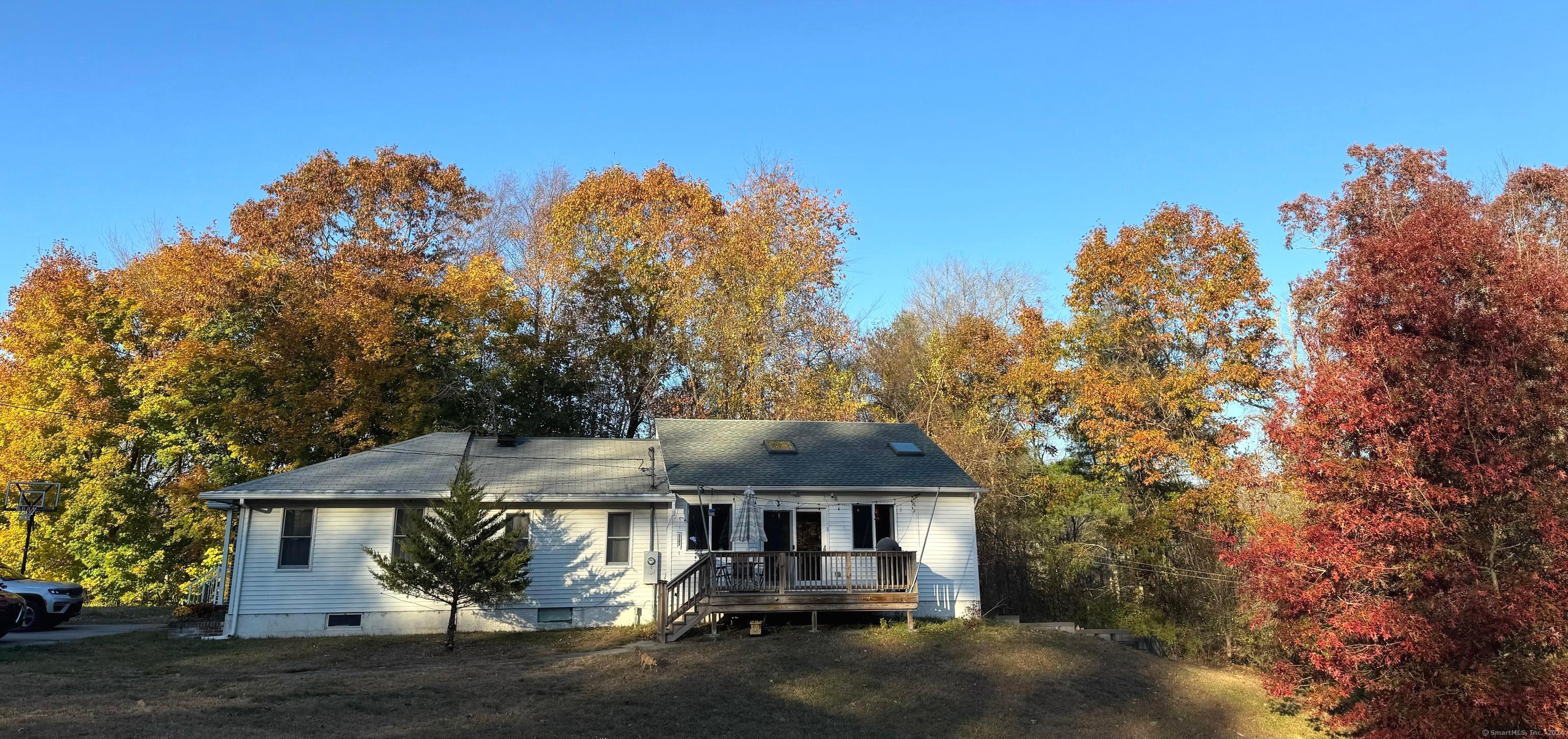 a front view of a house with a yard and mountain view in back