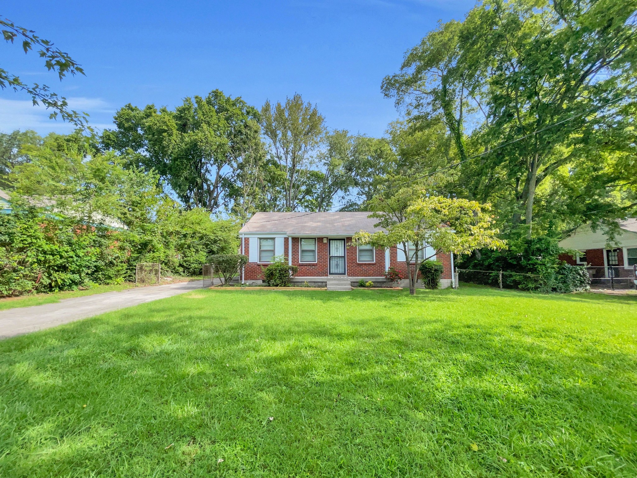 a view of a big yard with a house in the background