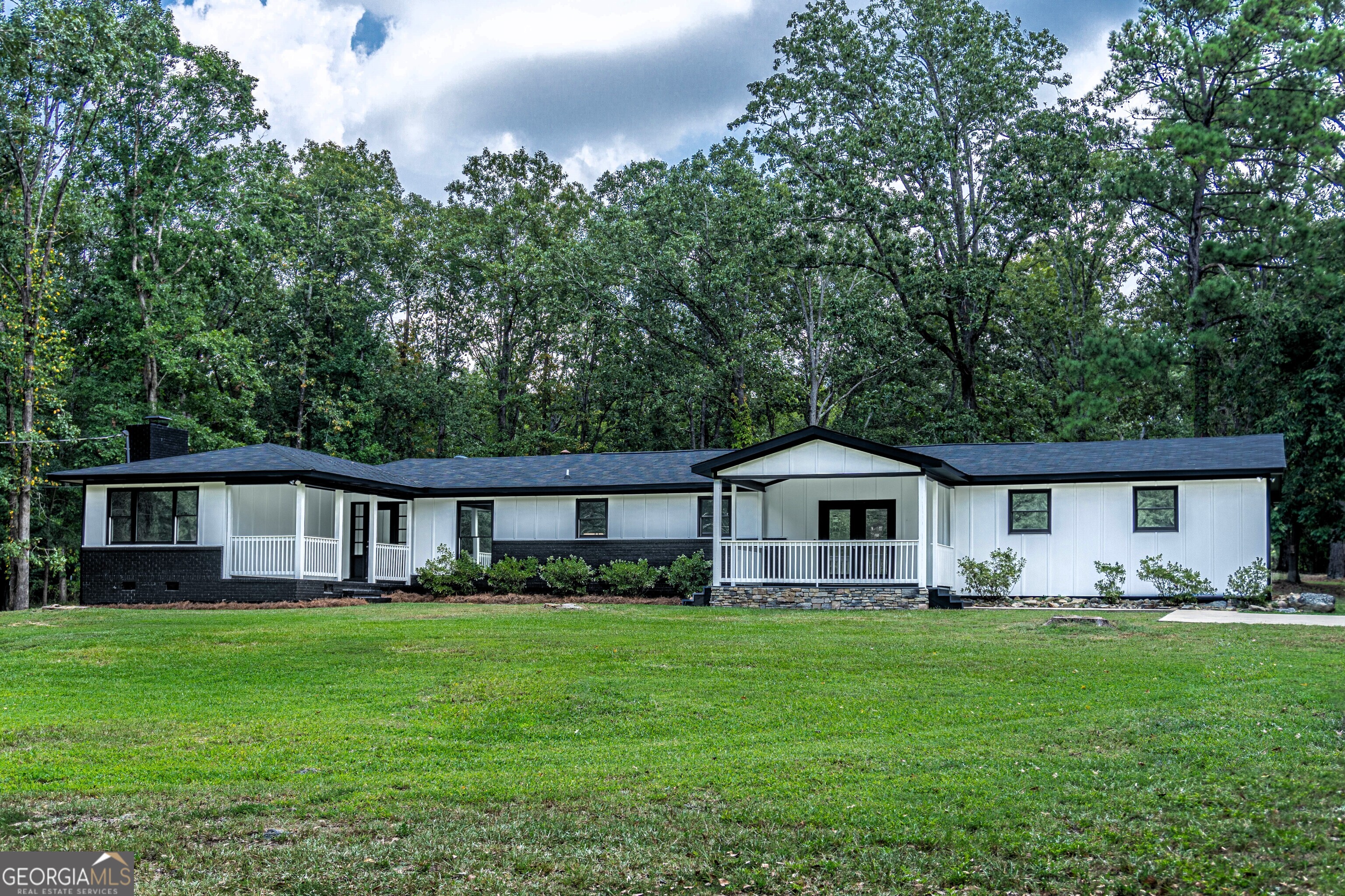 a front view of a house with a yard and trees