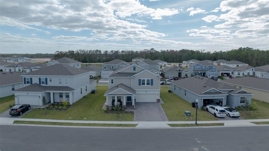 an aerial view of residential houses with outdoor space and parking